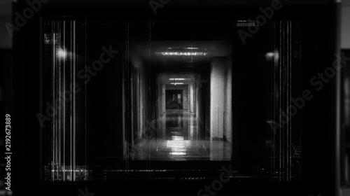 Grainy black and white surveillance footage from a security monitor in a corridor  