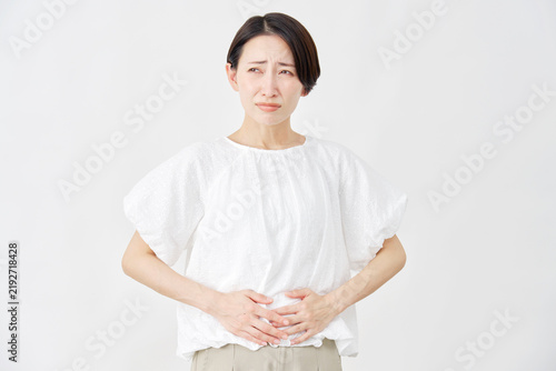 Foto ミドルエイジ女性　腹痛　白背景