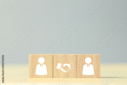 Wooden business people blocks with handshake icon represent partnership, agreement, teamwork, collaboration, negotiation, trust, networking, and successful business relationships. concept.