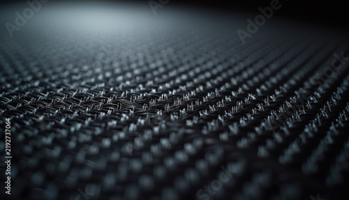 Close-up of textured black fabric with intricate pattern and depth of field detail, showcasing woven structure and shadows. Textured fabric offers versatility for various design applications,
