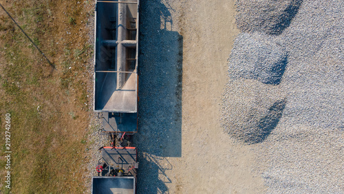 Fotografía Aerial View of a Railway Ballast Transport Wagon Near a Rail Track and Large Stockpiles of Ballast Rock in Karangsari, Indonesia