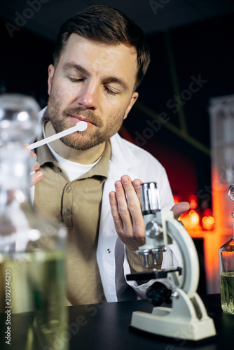 Obraz na plátně Perfumer analyzing perfume with a blotter, creating new scents and experiments i