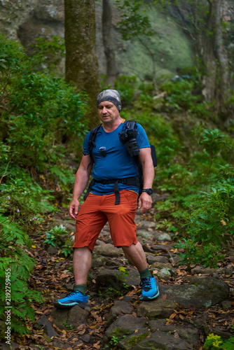 Hiker walking downhill on forest path