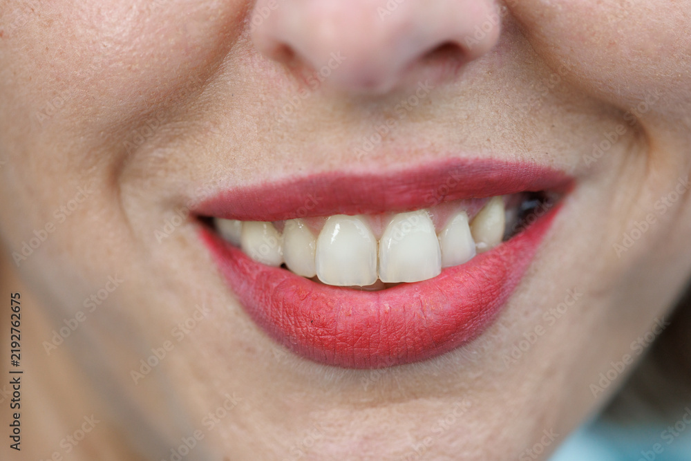 Obraz premium Close-up of smiling mouth with red lips and white teeth