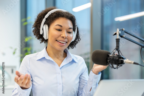 Foto Podcast host recording audio content, woman speaking into microphone for digital