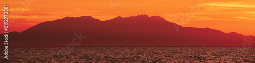 Seascape with mountains at sunset. Rockies in the evening. View of Mount Olympus on the horizon. Beautiful nature of Greece