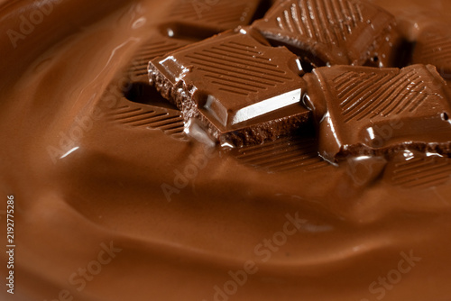 Foto Chocolate bar pieces melting into smooth warm liquid chocolate macro shot