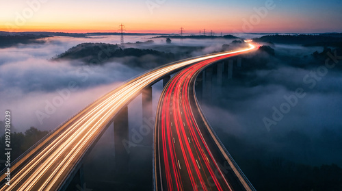 Highway bridge long exposure traffic lights light trails at sunset aerial view