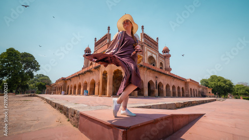 Foto Young woman twirling in front of Safdarjung Tomb in New Delhi, India