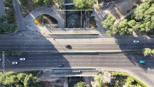 Top-down aerial view of river promenade park and dam infrastructure at early morning