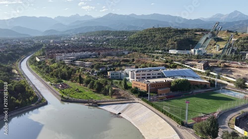 Top-down aerial view of river promenade park and dam infrastructure at early morning