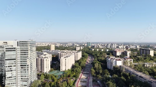Aerial view of modern glass skyscraper tower and city skyline along avenue at golden hour