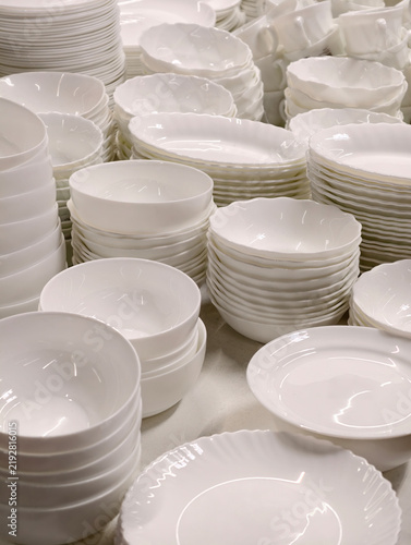 Foto White ceramic cups and plates shown on hypermarket shelves forming a minimal kit