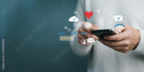 Person using smartphone with app icons like love, chat, email, and wifi signals floating around