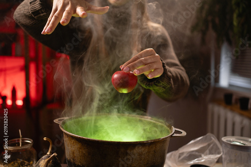 Foto She holds a red apple, waves her hand, and recites a spell