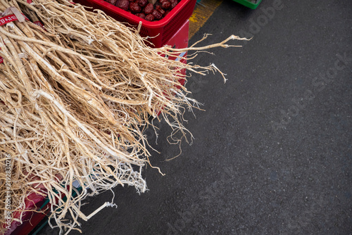Fotografie Bundles of dried astragalus milkvetch roots rest on a display stall at a traditional five day market in South Korea
