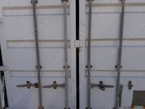 Obraz na płótnie White corrugated metal container doors closed and secured with industrial lockin