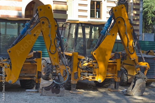 Foto Yellow backhoes parked on construction site