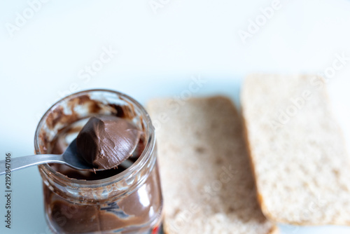 Spreading creamy chocolate spread on a slice of fresh toast with a knife