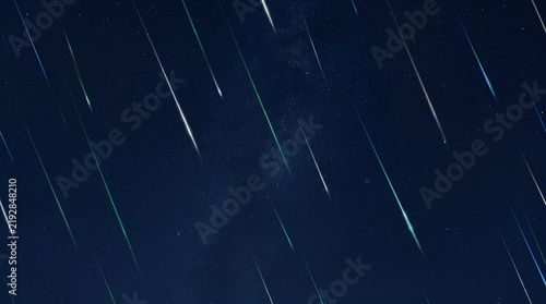 Meteor Shower Over Night Sky: Streaks of light, possibly meteorites or shooting stars, traverse a dark, starry sky, creating a breathtaking celestial spectacle.