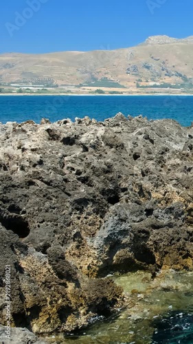 Vertical video of rocky shore of Crete Island with turquoise clear Mediterranean sea water. Greece.