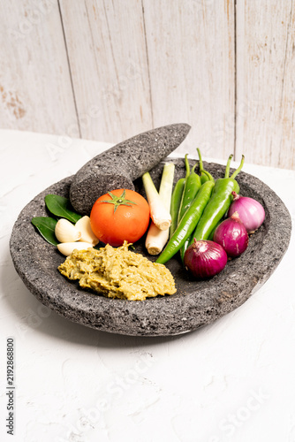 Indonesian green chilli paste on the stone mortar and pestle. 