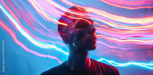 A young man surrounded by glowing colorful neon light waves emanating from his mind creating an artistic concept of cyber connection technology consciousness digital future energy vibrant creative vis
