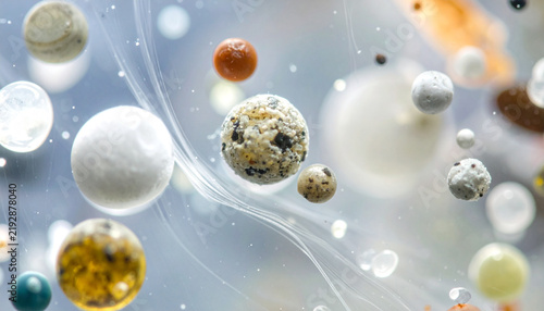 Abstract Spheres in Fluid: A cosmic dance of diverse abstract spheres, varying in texture and color, float ethereally within a swirling, fluid medium, creating a mesmerizing visual spectacle.