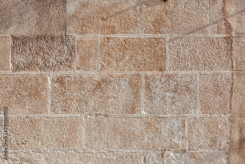 Foto Close-up of marnous calcarenite ashlar blocks showing intergranular porosity, tool marks, carbonate grain structure, and differential weathering typical of Apulian limestone masonry