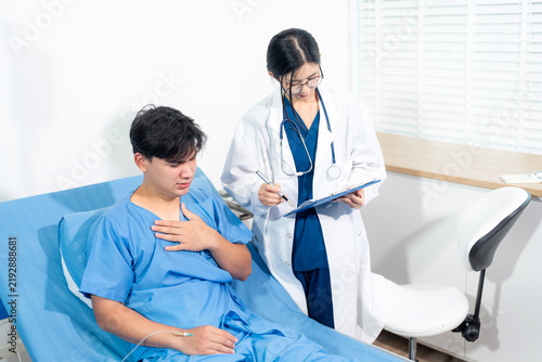 Friendly nurse taking care of patient man in a hospital room. Treatment of patients.