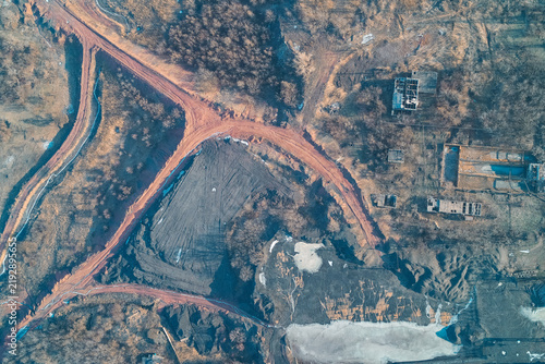 Aerial top view of coal mine territory and slag heap roads, industrial heavy mining infrastructure outdoors