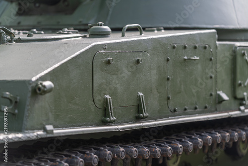 Bild auf Leinwand Details of an armored tank showcasing military design in a serene outdoor settin