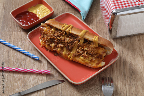 Un hot dog servi avec des garnitures et des sauces dans un restaurant