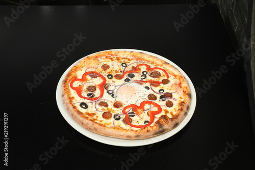 Фотография Une pizza avec des garnitures variées sur une table dans un restaurant rapide