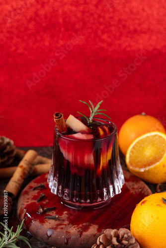 Konstfotografi Festive mulled wine with orange, cinnamon and rosemary on red background