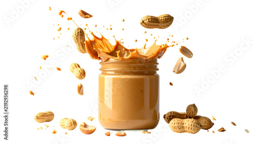 Jar of peanut butter with a splash and peanuts floating around on a black background