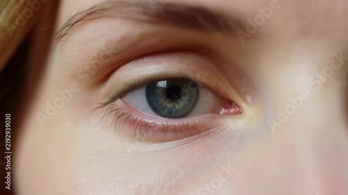 Extreme close-up of a human eye with subtle eyelid movement and a green-blue iris. Optometry advertising, ophthalmology education, and eye care campaigns.
