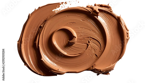 Swirled smear of brown cosmetic product with visible texture against a transparent backdrop