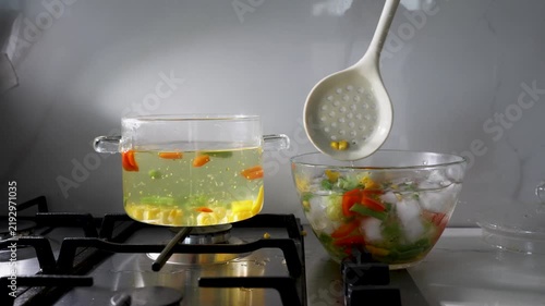 Boiling and blanching vegetables in a glass pot on a stovetop