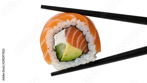 Fotografie Salmon avocado sushi roll held by black chopsticks, isolated on transparent back