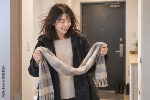 Fototapeta 帰宅してマフラーを外すと静電気で髪が広がった女性