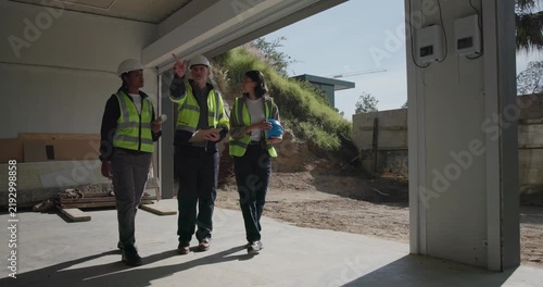 Construction, team and clipboard for building inspection, safety audit or project progress review. People, architect and electrician with site visit for remodeling quality, punch list and compliance