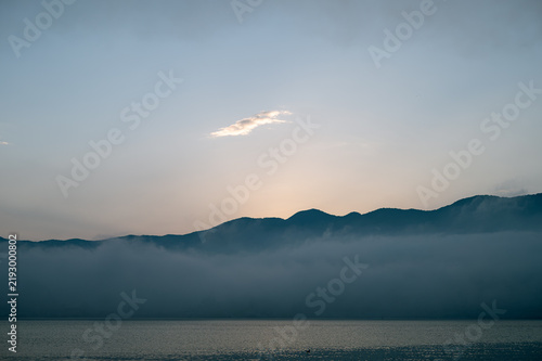 Thin cloud over mountains with thick morning fog before sunrise