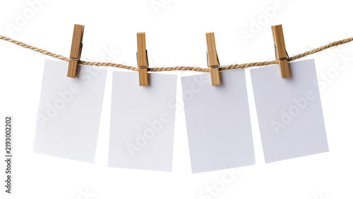 Four blank white paper cards held by wooden clothespins on a twine string, isolated on transparent background