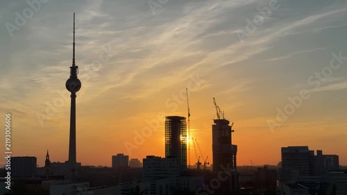 Urban development and city growth in Berlin, Germany: Aerial view of TV tower and high-rise buildings with cranes among them at sunset