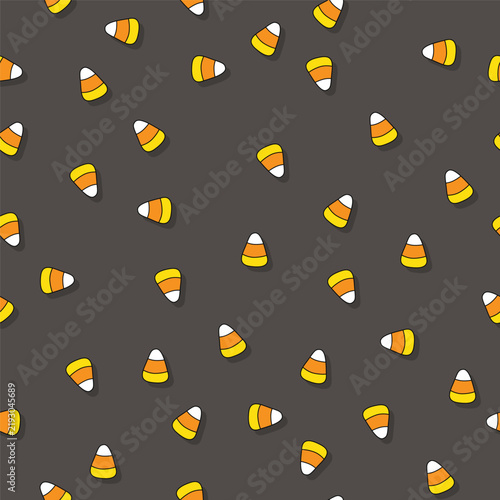 Seamless vector illustration of traditional Halloween candy corn pieces scattered on a dark background.