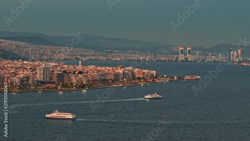Aerial View of Ferries Navigating Izmir Bay with City Skyline at Dusk Turkey