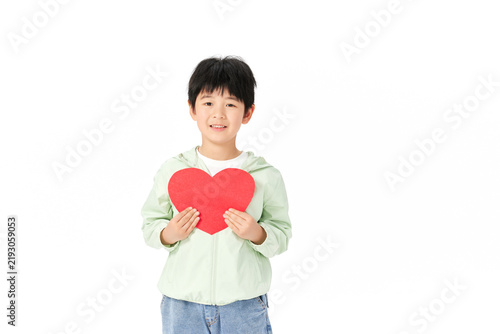 Foto Smiling Boy Holding Red Heart Shape for Love and Charity Concept