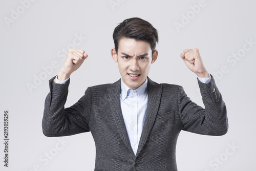 Fotografía Angry young businessman clenching fists in frustration