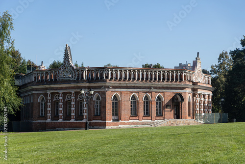 Photography The Opera House building with ornate red brick facade and gothic architectural details on green grass lawn in Tsaritsyno estate public park